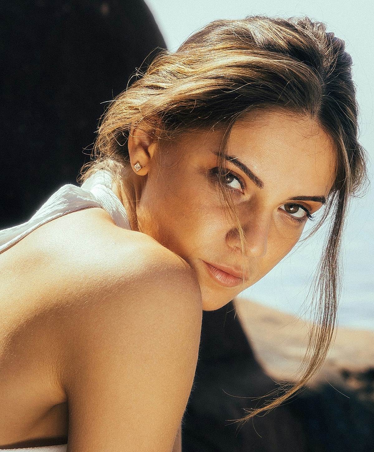 Woman looking over her shoulder, natural lighting.