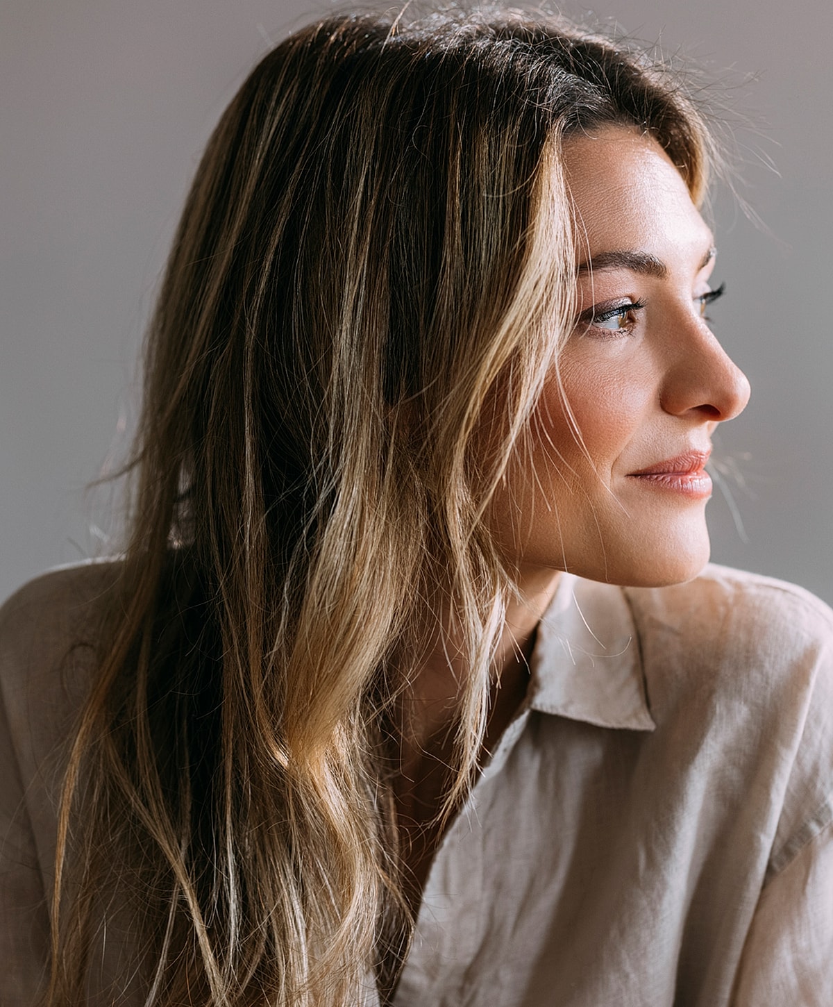Woman with long hair looking thoughtfully sideways.