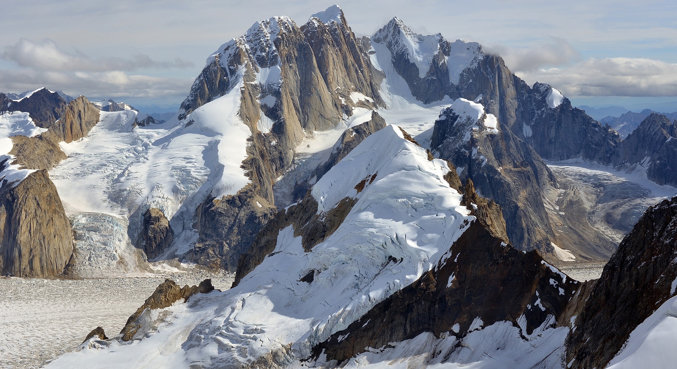 Snow-capped mountains with glaciers and rocky peaks.
