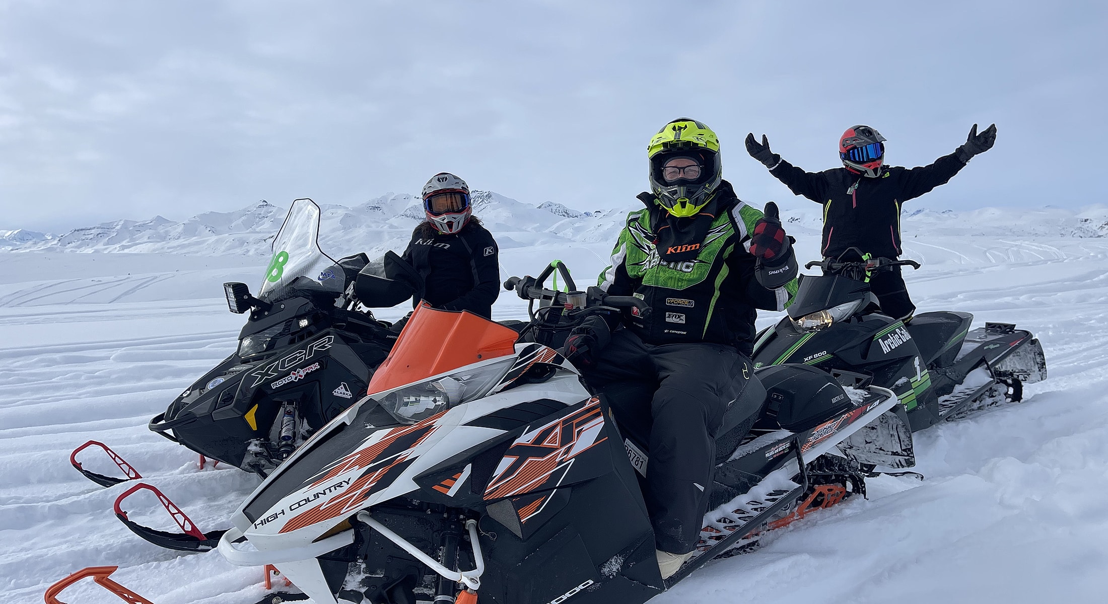Person on snowmobile in snowy mountainscape.
