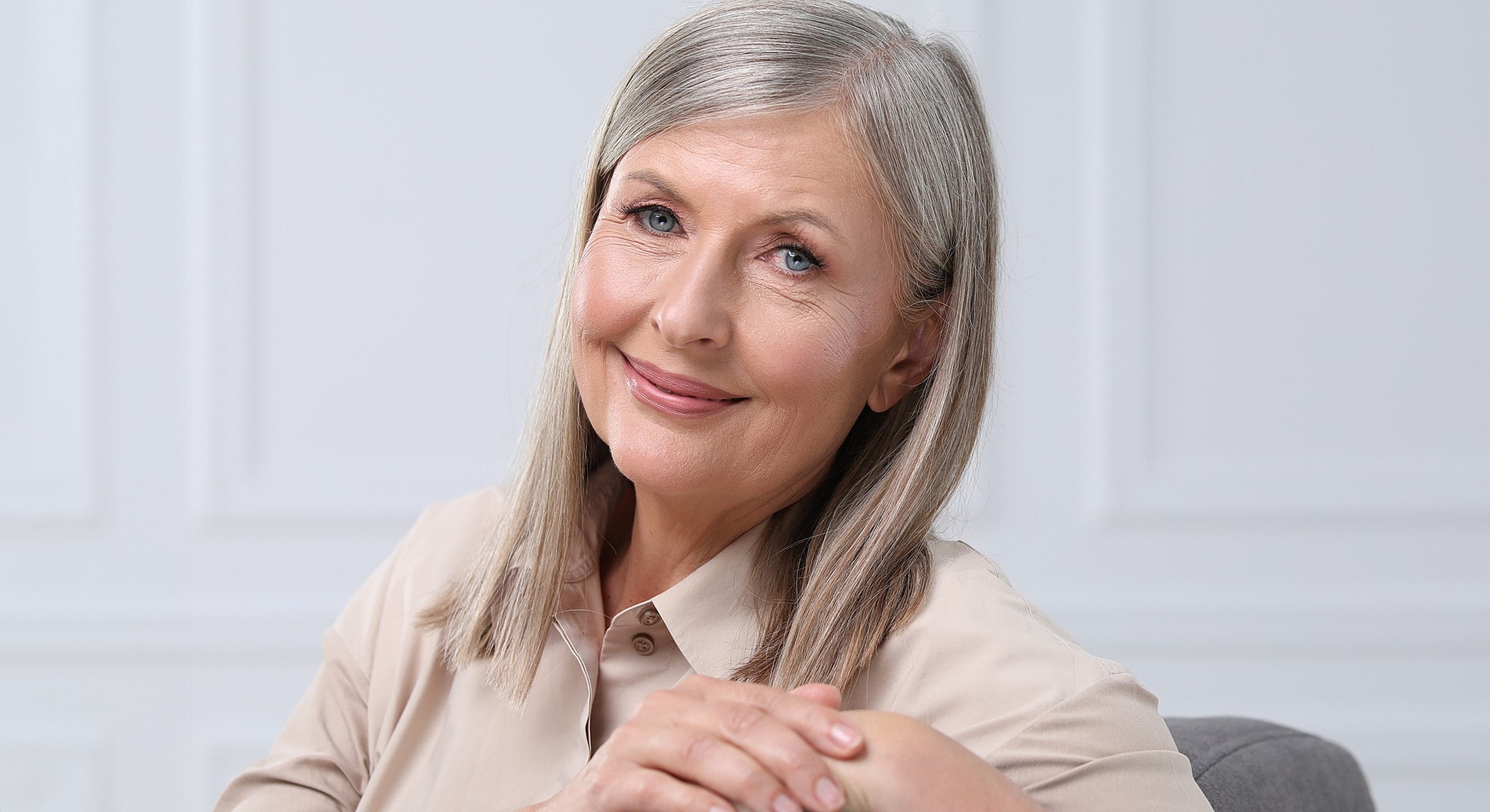 Smiling older woman with light hair and friendly expression.