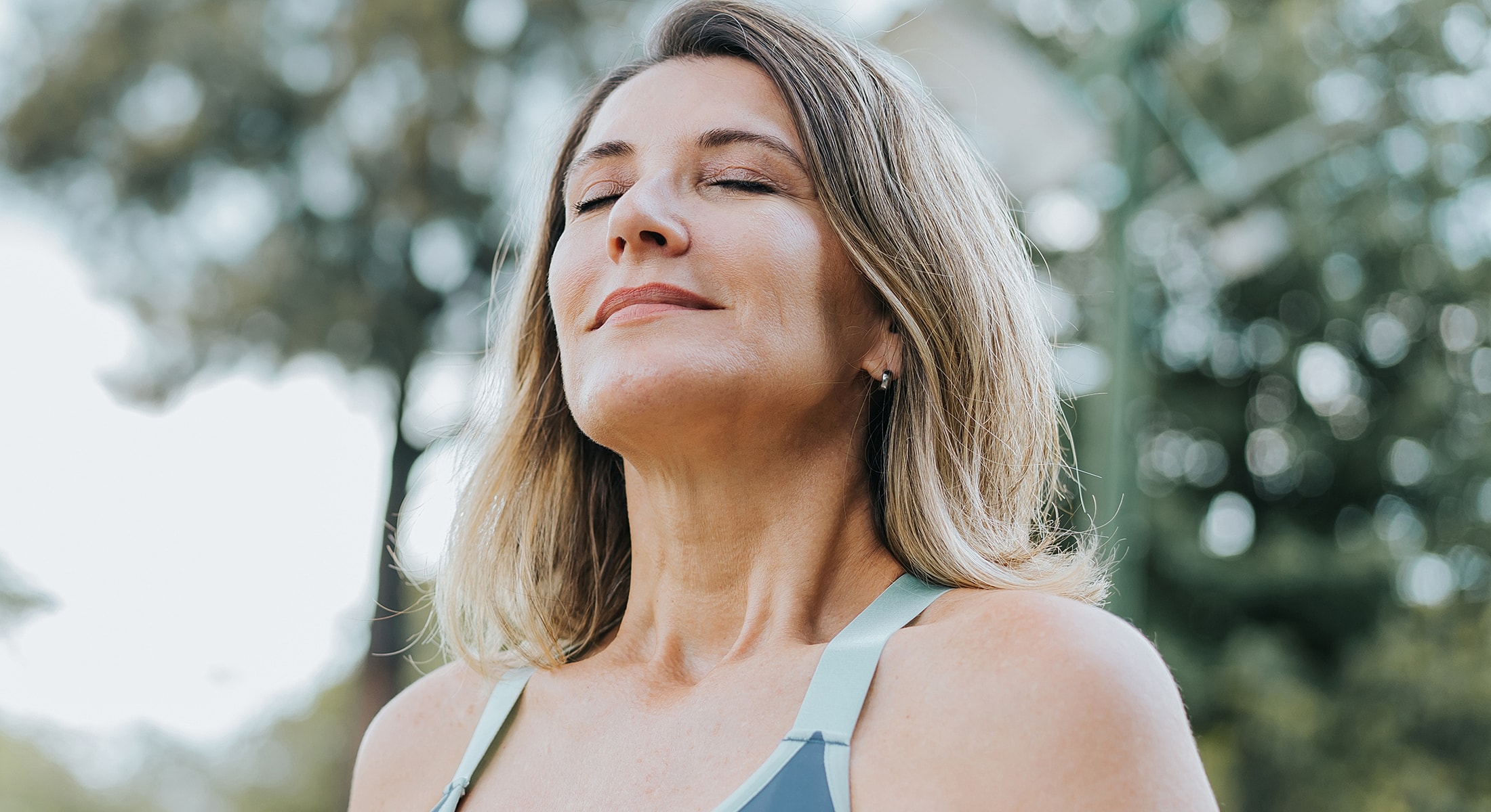 Woman practicing mindfulness outdoors with closed eyes.