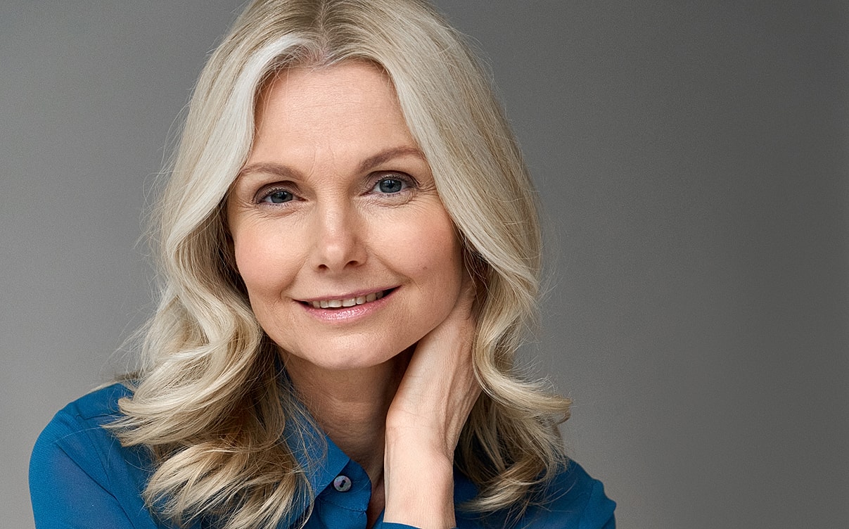 Smiling woman with long, wavy blonde hair.