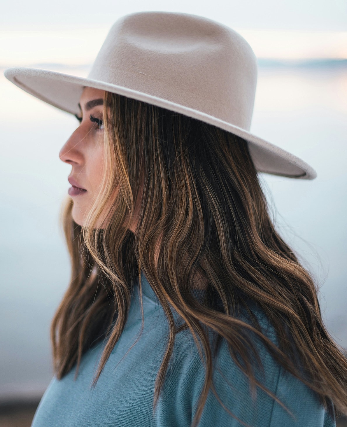 Woman with long hair wearing a wide-brimmed hat.