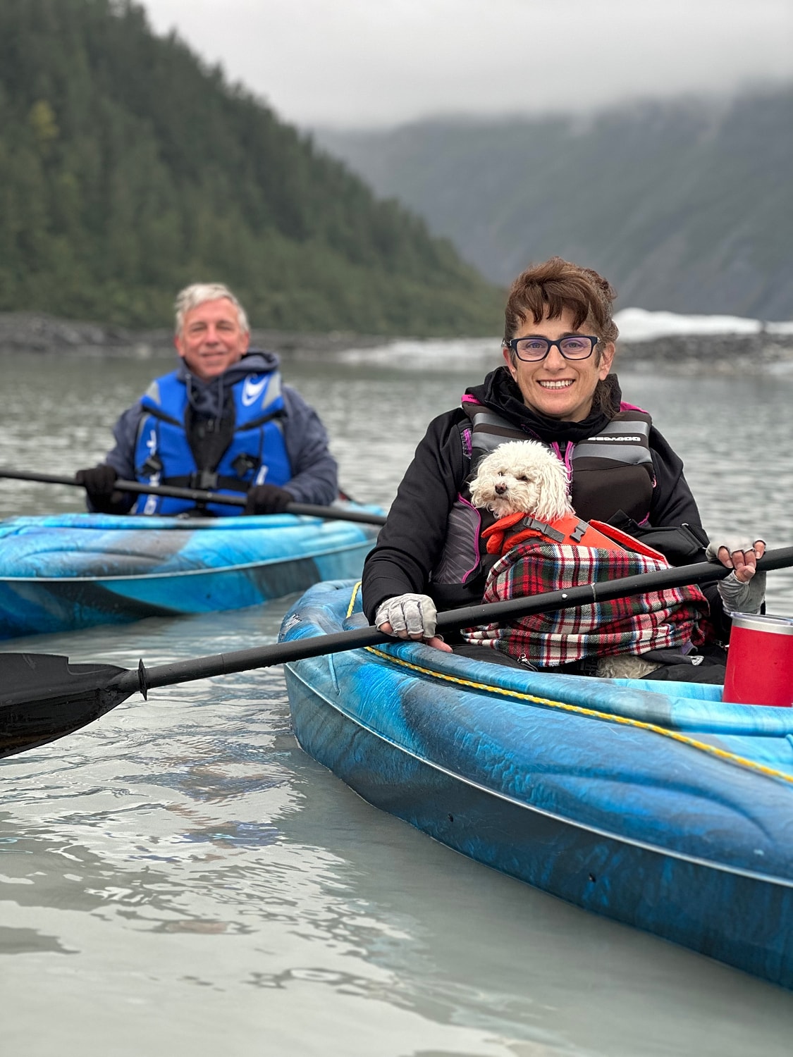 Kayakers enjoying time with a small dog.