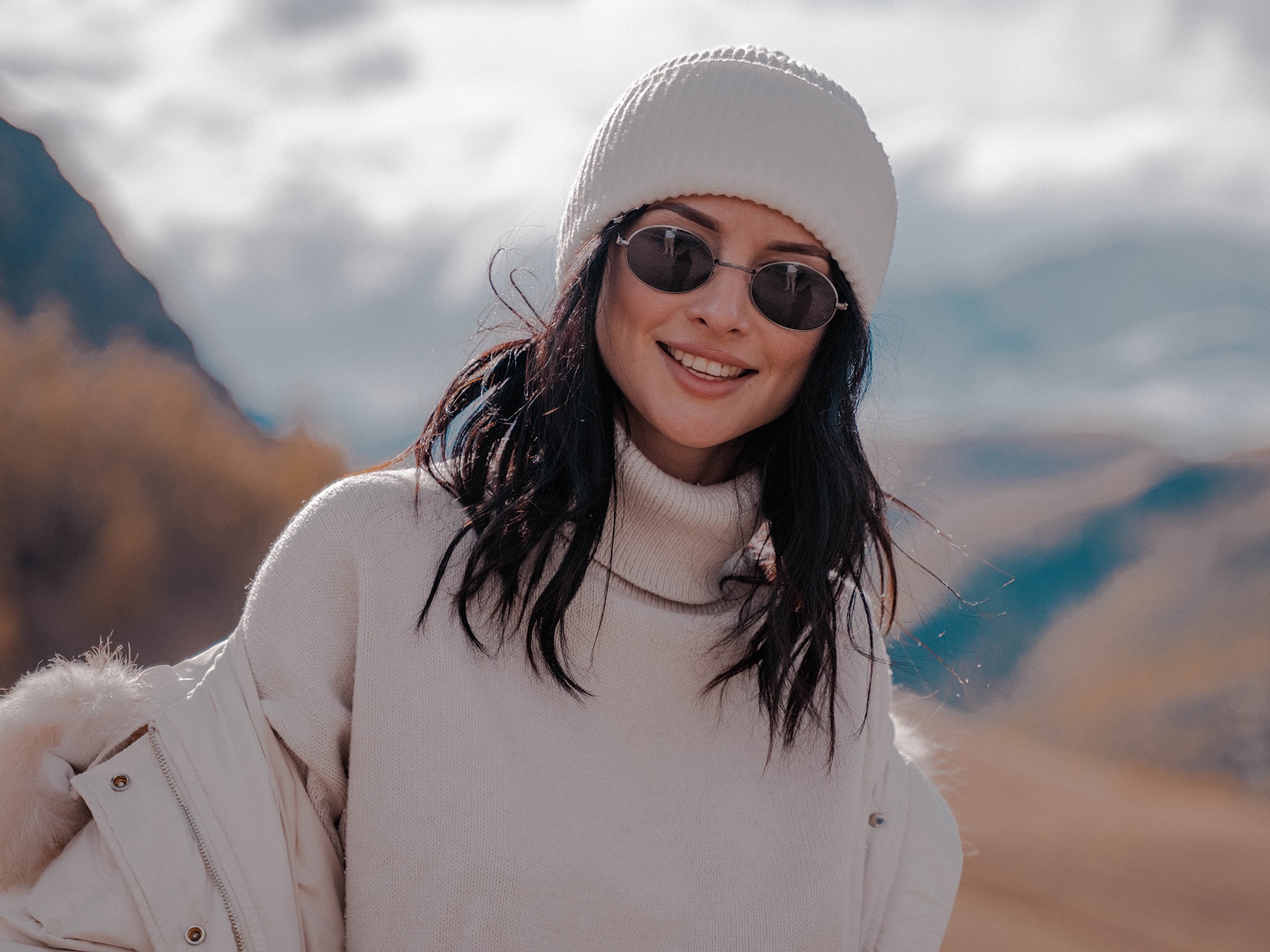 Smiling woman in winter clothing outdoors.